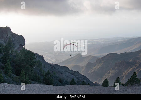 Zwei Gleitschirme fliegen zwischen Bergen Bergrücken in Teneriffa. Stockfoto