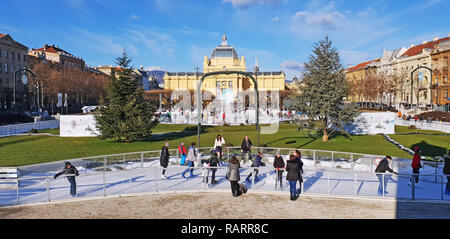 ZAGREB, KROATIEN - 04 Januar, 2019: Junge Menschen Schlittschuhlaufen auf der Eisbahn auf Adventszeit in König Tomislav Park am 04 Januar, 2019 in Zagr Stockfoto