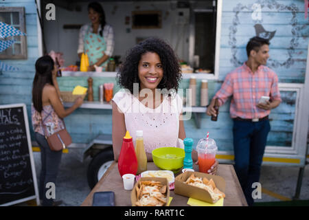 Porträt der schönen Frau am Tisch sitzen Stockfoto