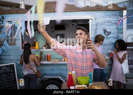 Mann unter selfie mit Bier Flasche aus Mobile Stockfoto