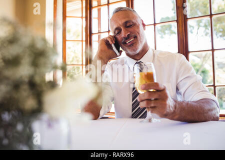Unternehmer Gespräch am Handy, während mit Weißwein Stockfoto