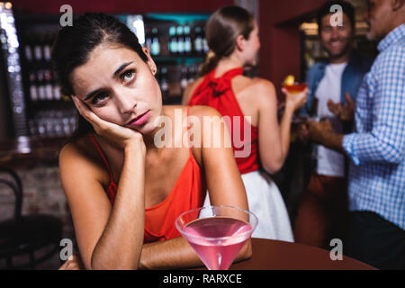 Verärgert Frau am Tisch sitzend in Nachtclub Stockfoto