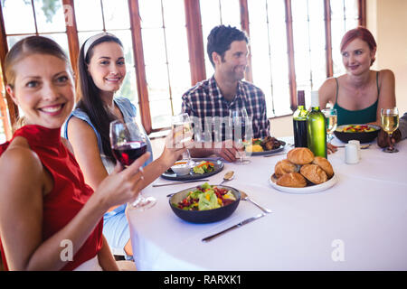 Freunde Essen und Wein am Tisch im Restaurant Stockfoto