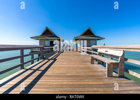 Blick auf Touristen und Einheimische am Naples Pier, beliebter Angelplatz mit türkisblauem Meer und Schwärme von Pelikanen. Stockfoto