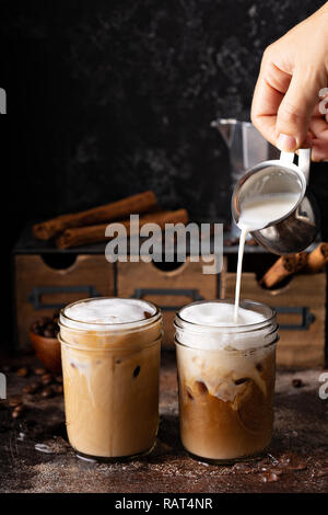 Kalte erfrischenden Eiskaffee im Maurer Gläser mit Milch über Gießen Stockfoto