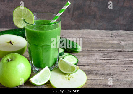 Grüne Smoothie in ein Glas mit Spinat, Apfel, Gurke und Limone mit einem Strohhalm. detox Drink. Nach oben Schließen Stockfoto