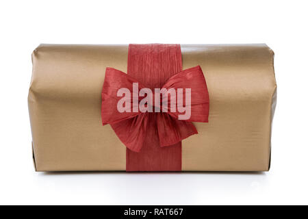 Geschenkbox in Gold Geschenkpapier eingewickelt, mit rotem raffia Band und Schleifchen verziert isoliert auf dem weißen Hintergrund Stockfoto