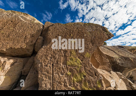 Petroglyphen, einschließlich menschliche Figuren, geschnitzt in Sandstein durch Ancestral Puebloan Leute an der Tsankawi prähistorischen Stätten in Bandelier National Monum Stockfoto