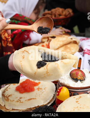 Die Hand Kaviar auf Pfannkuchen Stockfoto