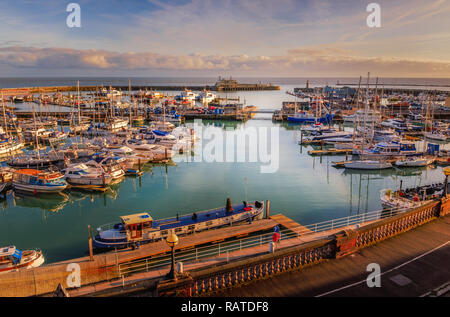 Der beeindruckende Eingang zum historischen Royal Hafen von Ramsgate, Kent, Großbritannien, voll von Freizeitaktivitäten und Angeln Boote aller Größen und einen grauen Rahmen kraft Bo Stockfoto