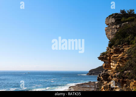 Spektakuläre Klippen auf der Manly Beach an der Küste zu Fuß mit Wellen, Meer/See und wolkenlosen Himmel in den frühen Morgenstunden (Sydney, Australien) Stockfoto