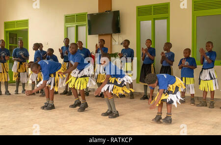 Schüler aus Bwindi Junior School Durchführen einer Tanz für Touristen vor dem Gorilla Trekking safari, Bwindi Impenetrable Nationalpark, Uganda Stockfoto