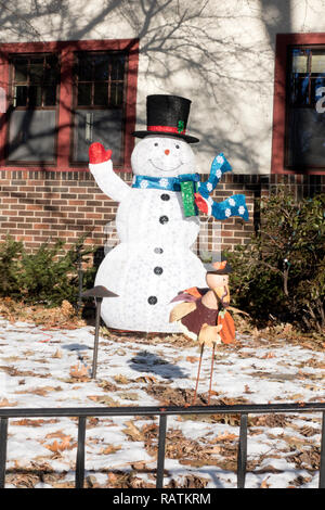Haus mit einem Winkenden Top eingerichtete hatted Holz Schneemann trägt einen blauen Schal, rot Handschuhe und ein Geschenk. St. Paul Minnesota MN USA Stockfoto
