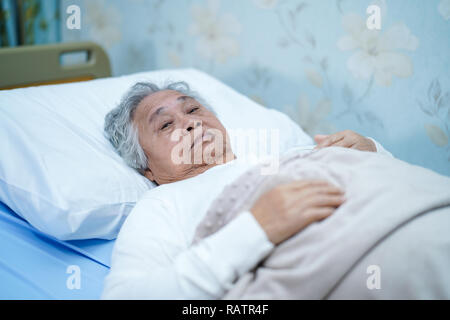 Asiatische Senior oder ältere alte Dame Frau Patienten Lächeln helles Gesicht mit starken Gesundheit beim liegen auf dem Bett in der Krankenpflege Krankenhaus: gesunde Medizin. Stockfoto