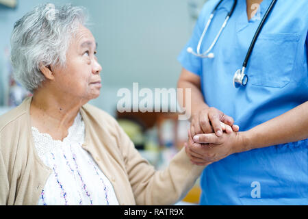 Halten Sie den Asiatischen Senior oder ältere alte Dame Frau Patienten mit Liebe, Pflege, Unterstützung, Förderung und Einfühlungsvermögen an der Krankenpflege Krankenhaus. Stockfoto