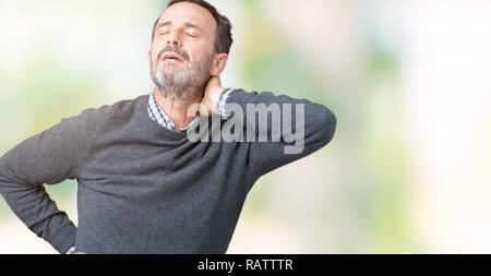 Stattliche mittleren Alters älterer Mann mit einem Pullover über isolierte Hintergrund Leiden der Nacken Schmerzen Verletzungen, Hals mit der Hand berühren, Muskelschmerzen Stockfoto