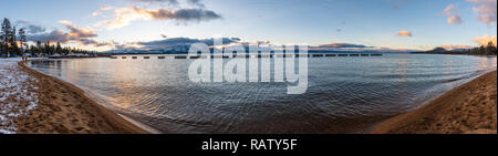 Sonnenuntergang an der Küste von South Lake Tahoe, Sierra Berge bedeckt mit Schnee im Hintergrund sichtbar, Kalifornien Stockfoto