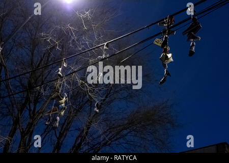 Schuhe hängen an einem Telefon Kabel Stockfoto