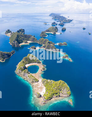 Remote Kalkstein Inseln Aufstieg von der atemberaubenden Küstenlandschaft in Raja Ampat, Indonesien. Dieser vielfältigen Region ist als Herz der Korallen Dreieck bekannt. Stockfoto