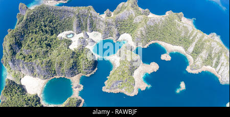 Remote Kalkstein Inseln Aufstieg von der atemberaubenden Küstenlandschaft in Raja Ampat, Indonesien. Dieser vielfältigen Region ist als Herz der Korallen Dreieck bekannt. Stockfoto