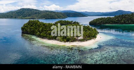 Ein remote Kalkstein Insel ist durch gesunde Riff in Raja Ampat, Indonesien umgeben. Dieser vielfältigen Region ist als Herz der Korallen Dreieck bekannt. Stockfoto