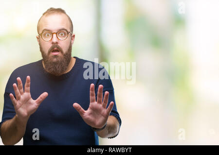 Junge kaukasier hipster Mann mit Sonnenbrille über isolierte Hintergrund Angst und Furcht Ausdruck stop Geste mit den Händen Angst, in Schreien Stockfoto