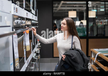 Frau finden sich Ofen oder Herd in einem Supermarkt Stockfoto