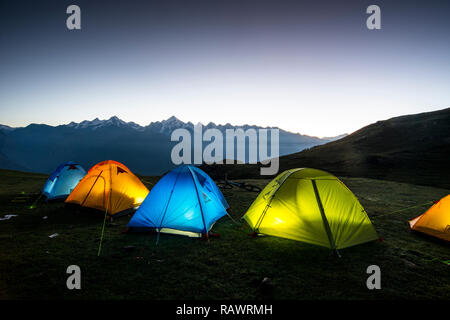 Eine Reihe von Zelten in der Dämmerung Khalia oben über der Stadt Munsyari in Uttarakhand, Indien Himalaya. Die Panchchuli gipfeln in der Ferne. Stockfoto