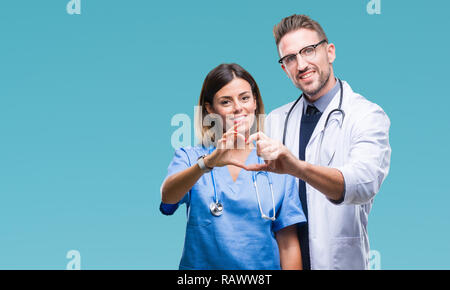 Junges Paar von Arzt und Chirurg über isolierte Hintergrund lächelnd in Liebe mit Herz und Formen mit den Händen. Romantische Konzept. Stockfoto