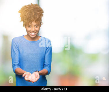 Schöne junge afrikanische amerikanische Frau über isolierte Hintergrund lächelnd mit Hände Handflächen geben oder empfangen Geste. Halt und Schutz Stockfoto