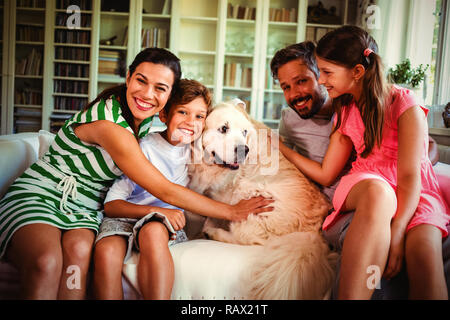 Familie mit Hund sitzt auf einem Sofa im Wohnzimmer. Stockfoto