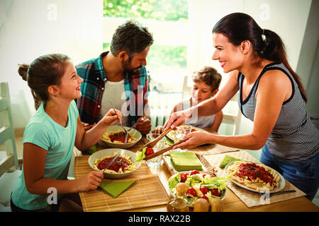 Lächelnde Frau Essen Familie mit Stockfoto