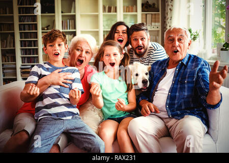 Glückliche Familie vor dem Fernseher im Wohnzimmer Stockfoto
