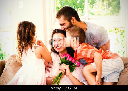 Mutter empfangenden Blumenstrauß von ihrer Familie Stockfoto