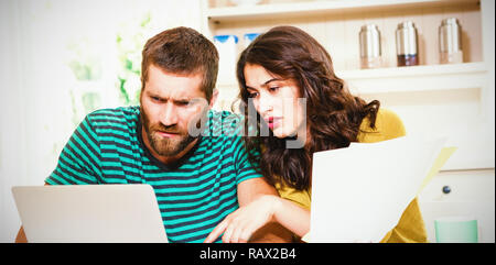 Paar, die Bezahlung ihrer Rechnungen mit Laptop in Küche Stockfoto