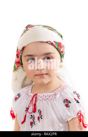 Nahaufnahme von einem jungen Mädchen mit dem Kopf in der traditionellen Tracht gekleidet. Rumänische Folklore. Posieren in einem Studio auf einem weißen Hintergrund. Stockfoto