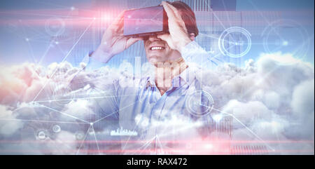 Das zusammengesetzte Bild von lächelnden Geschäftsmann im blauen Hemd tragen VR-Brille Stockfoto
