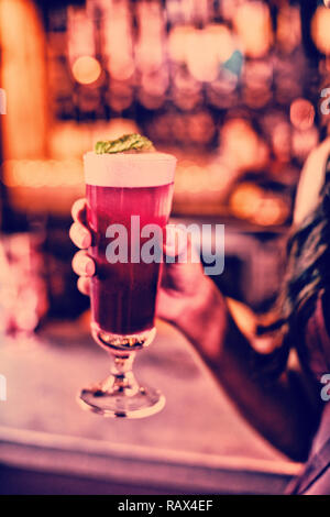 Frau mit einem Glas Pink cocktail Stockfoto