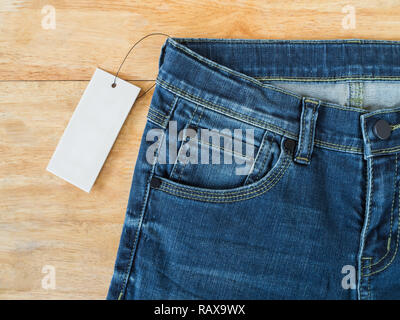 Blick von oben auf die blaue Jeans mit weißen leer Preis auf Holz Textur Hintergrund Stockfoto
