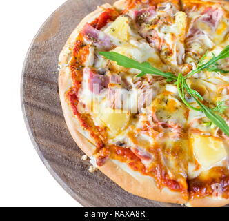 Heiß in Scheiben geschnitten Pizza Hawaii auf einem Holzbrett und einem weißen Hintergrund. Stockfoto
