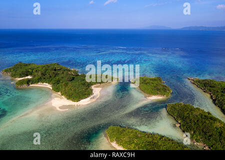 Luftaufnahme über einzigartige kleine tropische Inseln mit weißen Sandstränden, Korallenriffen und Boote, von Drone, Kabira Bay, Ishigaki, Japan Stockfoto