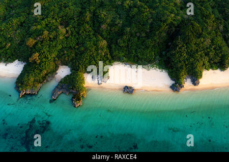 Luftaufnahme über einzigartige tropische Insel mit Berge, einsame weisse Sandstrände und Coral Reef, bei Sonnenuntergang, von Drohne, Ishigaki, Japan Stockfoto
