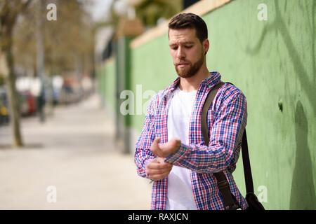 Attraktiven jungen Mann, der im städtischen Hintergrund. Guy legere Kleidung. Lifestyle Konzept. Stockfoto