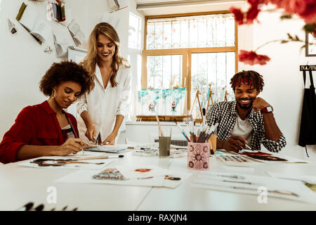Zwei fröhliche strahlende Kunst Studenten hören auf ihre Lehrer Stockfoto