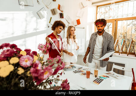 Kunst Studenten in eingerichtete Studio in der Nähe von weißen Tisch mit Blumen Stockfoto