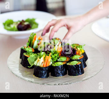 Raw vegan Sushi Rollen mit Gemüse und grüne Soße im Restaurant Stockfoto