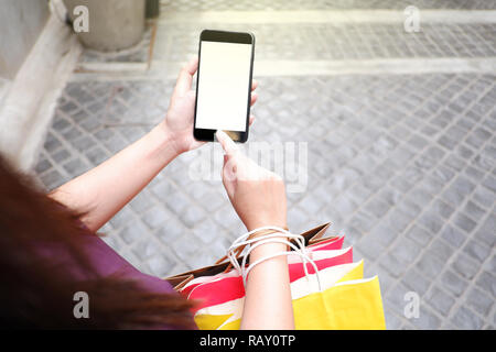 Nahaufnahme der Frau mit ihrem Smartphone während des Einkaufs Stockfoto