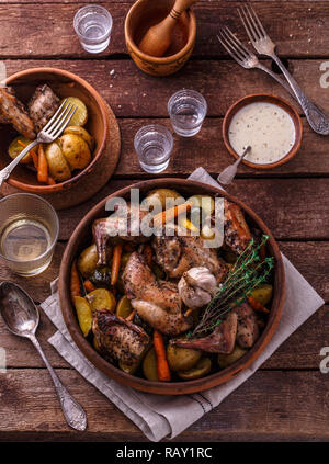 Kaninchen mit Kartoffeln und Karotten gebacken in einem keramiktopf. Stockfoto