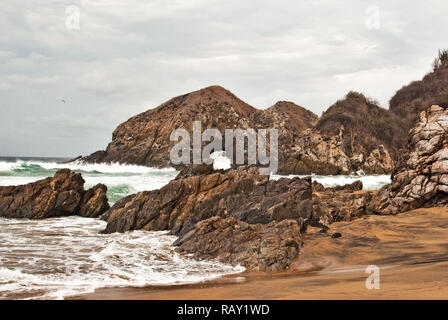 Wellen auf die Felsen während einer Reise im Sommer an den Strand. Stockfoto