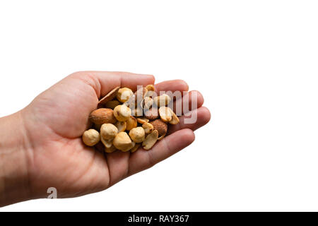 Eine Hand hält eine breite Auswahl an Nüsse und Samen mit isolierten weißen Hintergründen Stockfoto